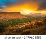 Experience the stunning sunset over a Berber village in Dades Valley, Tinghir, Morocco. This scenic view of Todra Gorge captures the essence of traditional rural life.