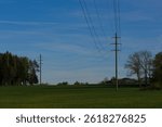 Experience tranquil modernity: a sleek powerline stretches beneath an endless blue sky, merging technology with open, serene nature in a dynamic visual composition.
