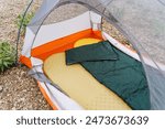 Experience ultimate outdoor comfort with a cozy camping setup. Includes a sturdy tent, insulated sleeping bag, soft pillow, and comfortable sleeping pad on a gravel ground surface.