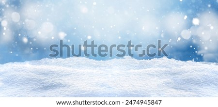 Experience a winter setting with snowflakes falling against a blue sky. Enjoy the tranquility of this serene landscape