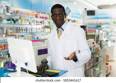 Experienced African American Guy Pharmacist Working On Computer In Modern Pharmacy