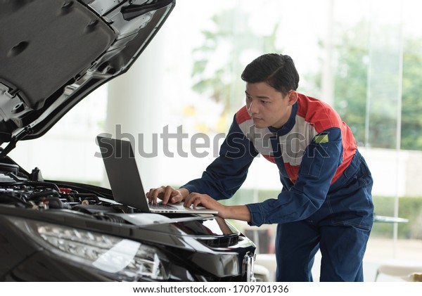 Experienced auto mechanic checking Computer\
diagnostics of cars