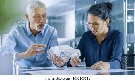 Experienced Automotive Designer and Female Engineer Works with a Concept Car Prototype Model, Perfecting it and Making Design Corrections. They Work in a Stylish, Bright, Modern Office. - Powered by Shutterstock