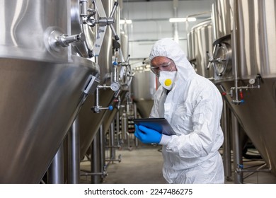 Experienced beer tech carrying out the quality control of equipment - Powered by Shutterstock