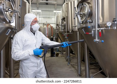 Experienced beer tech cleaning and sanitizing the brewing equipment - Powered by Shutterstock