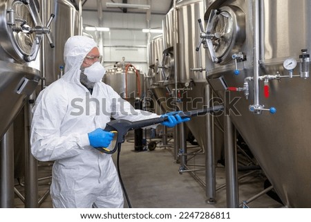 Experienced beer tech cleaning and sanitizing the brewing equipment