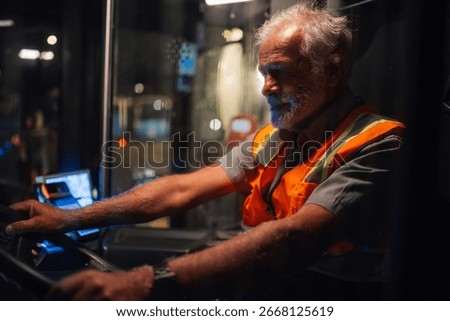 Experienced bus driver navigating bustling city streets at night, ensuring safe transport for passengers during late night shifts