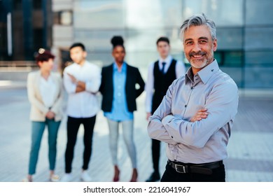 An Experienced Businessman Standing In Front Of His Team