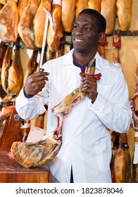 Experienced Butcher Shop Owner Checking Quality Of Jamon Before Sale..