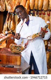 Experienced Butcher Shop Owner Checking Quality Of Jamon Before Sale..