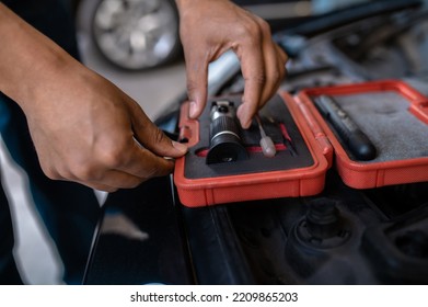 Experienced Car Service Station Worker Choosing An Optical Device