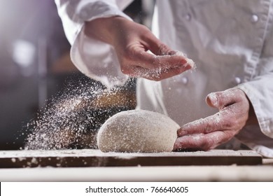 An experienced chef in a professional kitchen prepares the dough with flour to make the bio Italian pasta. the concept of nature, Italy, food, diet and bio.