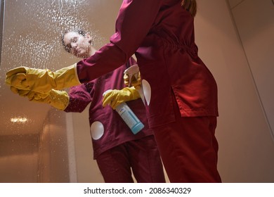 Experienced Cleaner Cleaning Mirrored Surface In Apartment Hallway