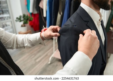 Experienced clothier altering suit jacket of client