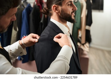 Experienced clothier altering suit of male client