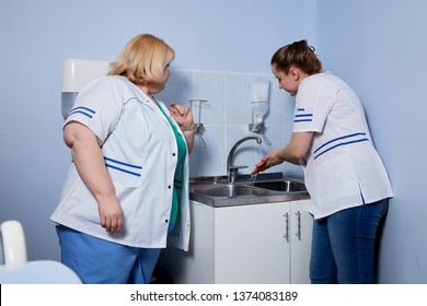 Experienced doctor fat woman teaching aspiring young doctor how to wash handsand before meeting with the patient at the hospital in Russia