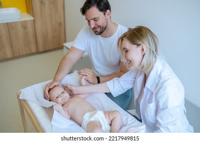 Experienced Doctor Performing A Neonatal Exam In The Dad Presence