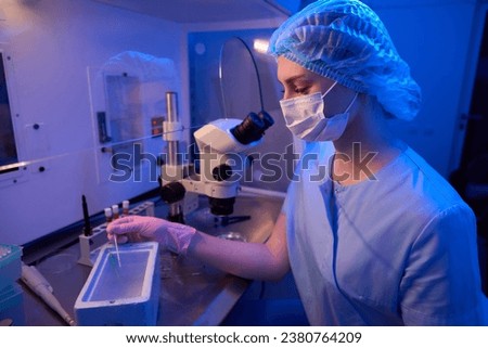 Experienced embryologist is performing cryogenic preservation of embryos in lab