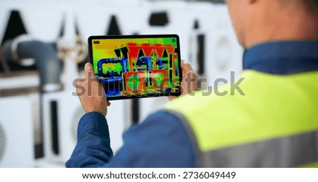 Experienced Engineer Inspects HVAC System Using Thermal Camera For Maintenance.