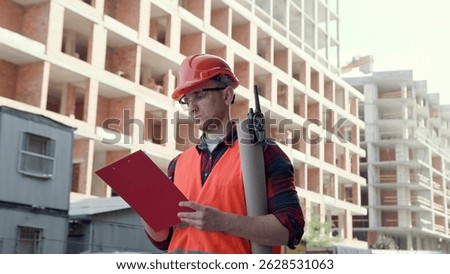 Experienced foreman taking notes during building site inspection