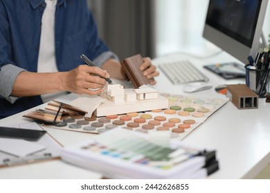 Experienced interior designer working with material and color samples at his workplace - Powered by Shutterstock