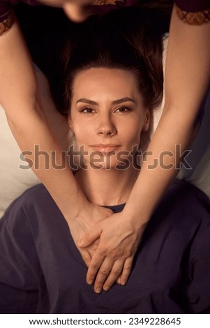 Experienced massage therapist working client pectoral muscles