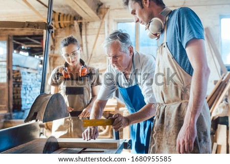 Similar – Image, Stock Photo Master carpenter and apprentice using a clamp for wood gluing in a workshop