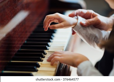 experienced master piano hand helps the student, close-up