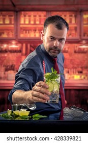 Experienced Middle Age Bartender Mixologist Present Mojito Style Cocktail In Old Dark Modern Bar Red Tie 