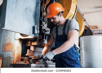 Experienced operator in a hard hat. Metalworking industry concept professional engineer metalworker operating CNC milling machine center in manufacturing workshop. - Shutterstock ID 1154944261