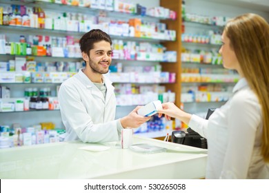 Experienced Pharmacist Counseling Female Customer In Modern Pharmacy
