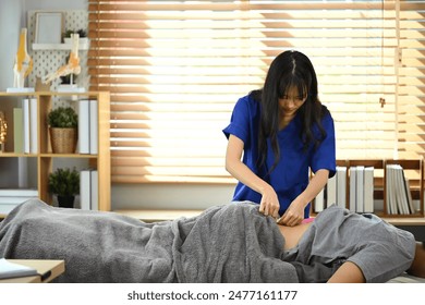 Experienced physiatrist using kinesiology taping method for patient low back pain. Kinesiology and rehabilitation concept - Powered by Shutterstock