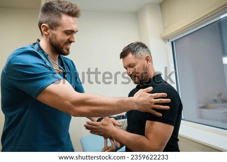 Experienced physiotherapist testing upper extremity strength in patient