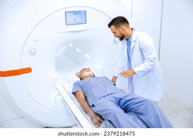 Experienced radiologist encouraging senior patient before MRI or CT scanning procedure in hospital. - Powered by Shutterstock