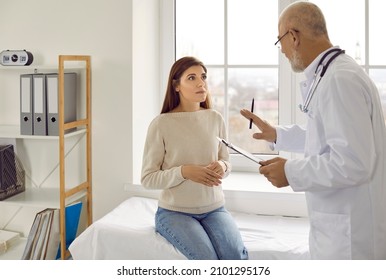 Experienced senior doctor at modern clinic talking to nervous female patient. Supportive adult physician trying to calm down worried young woman and asking her to relax before medical exam - Powered by Shutterstock