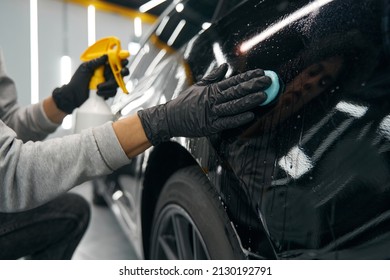 Experienced Service Station Worker Removing Contaminants From Automobile Surface