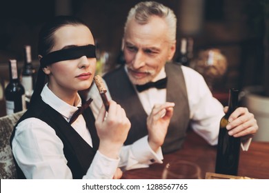 Experienced Sommelier With Bandage On Eyes Sniff Cork From Bottle Of Wine At Corkscrew. Wine Tasting. Checking Taste, Color, Sediments Of Wine.