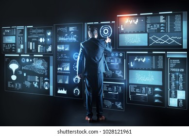 Experienced specialist. Clever qualified professional IT manager standing in front of a futuristic giant device and thoughtfully touching its screen