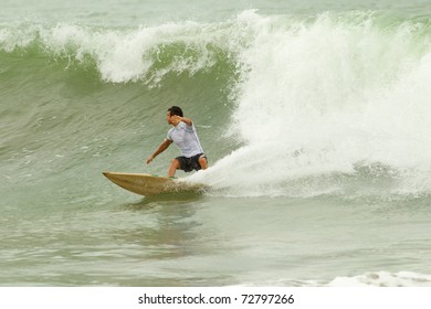 Experienced surfer eagerly readies to conquer the mighty wave,fueled by passion and determination.