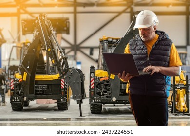 Experienced Technician Analyzing Heavy Machinery with Laptop at Industrial Site - Powered by Shutterstock