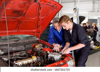 An Experienced Trainer Teaching His Student About The Parts Of An Automobile In A Vocational School Of Automotive Trade