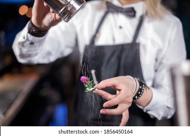 Experienced woman bartending formulates a cocktail in the nightclub