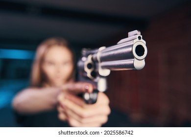 Experienced woman shooter holding a pistol with both hands