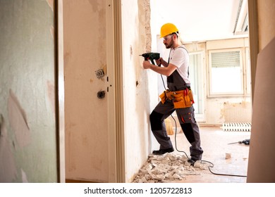 Experienced Worker Using Hammer Drill For Tearing Down A Wall Structure