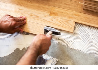 Experienced Worker   Using  Hammer For Parquet Alignment And Dimensional Stability Of The Floor Surface