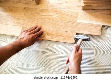 Experienced Worker   Using  Hammer For Parquet Alignment And Dimensional Stability Of The Floor Surface