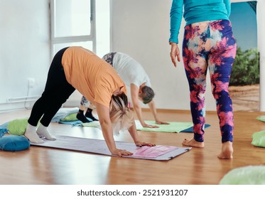 Experienced yoga instructor demonstrating safe and effective exercises for seniors to improve flexibility and balance. - Powered by Shutterstock