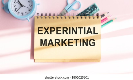 Experiential Marketing written on paper,Wooden background desk with calculator,dice,compass,smart phone and pen.Top view conceptual.