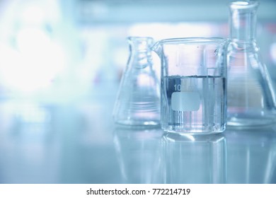 experiment water in beaker and flask in blue chemistry science laboratory background - Shutterstock ID 772214719