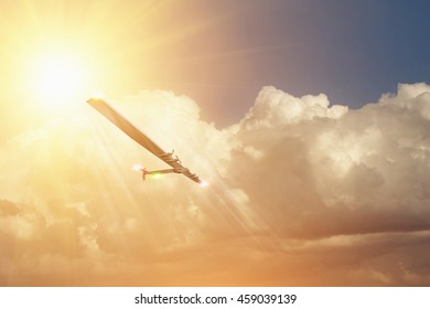 Experimental Aircraft On Sun Energy. Solar Impulse In Cloudy Sky With Sunlight 